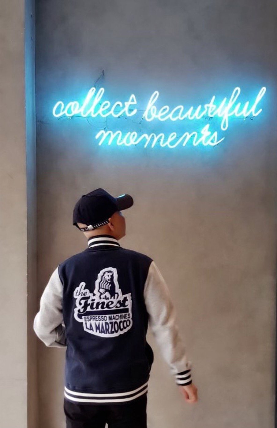 La Marzocco varsity jacket by a neon sign